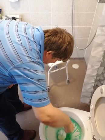 Andrew cleaning a toilet