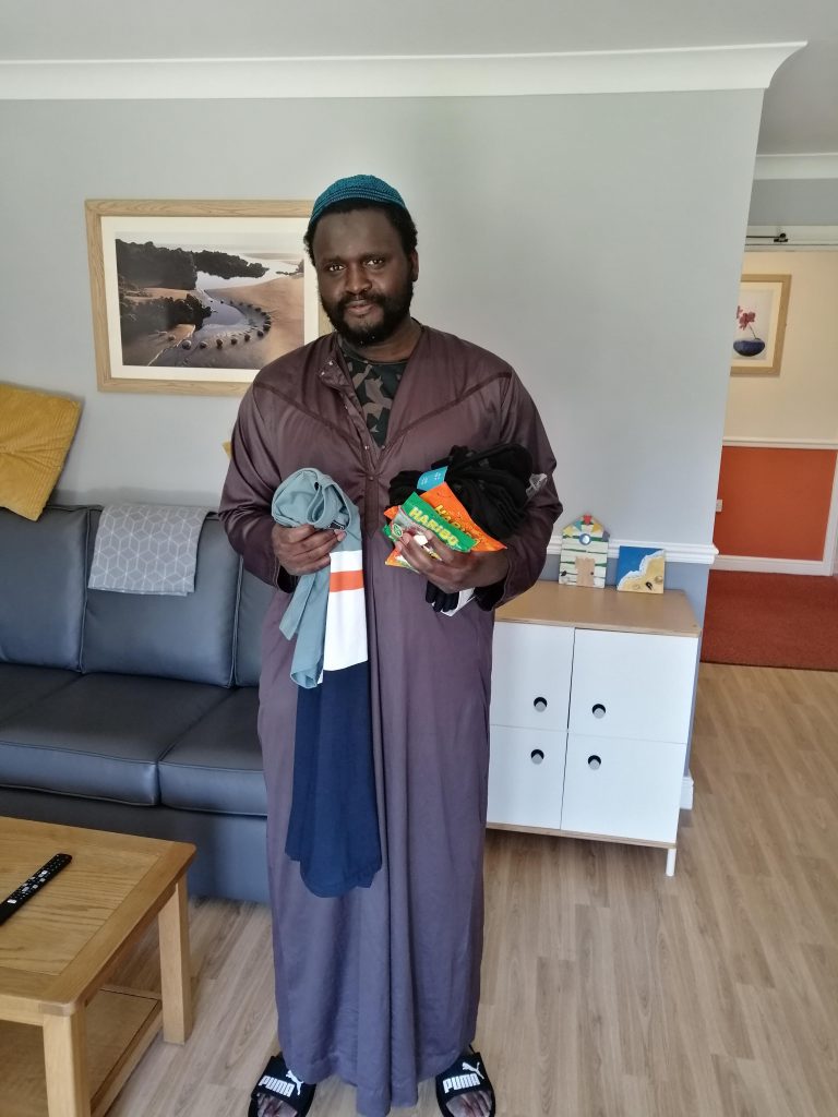 Lamin stood holding his gifts given to him to celebrate Eid Al-Adha