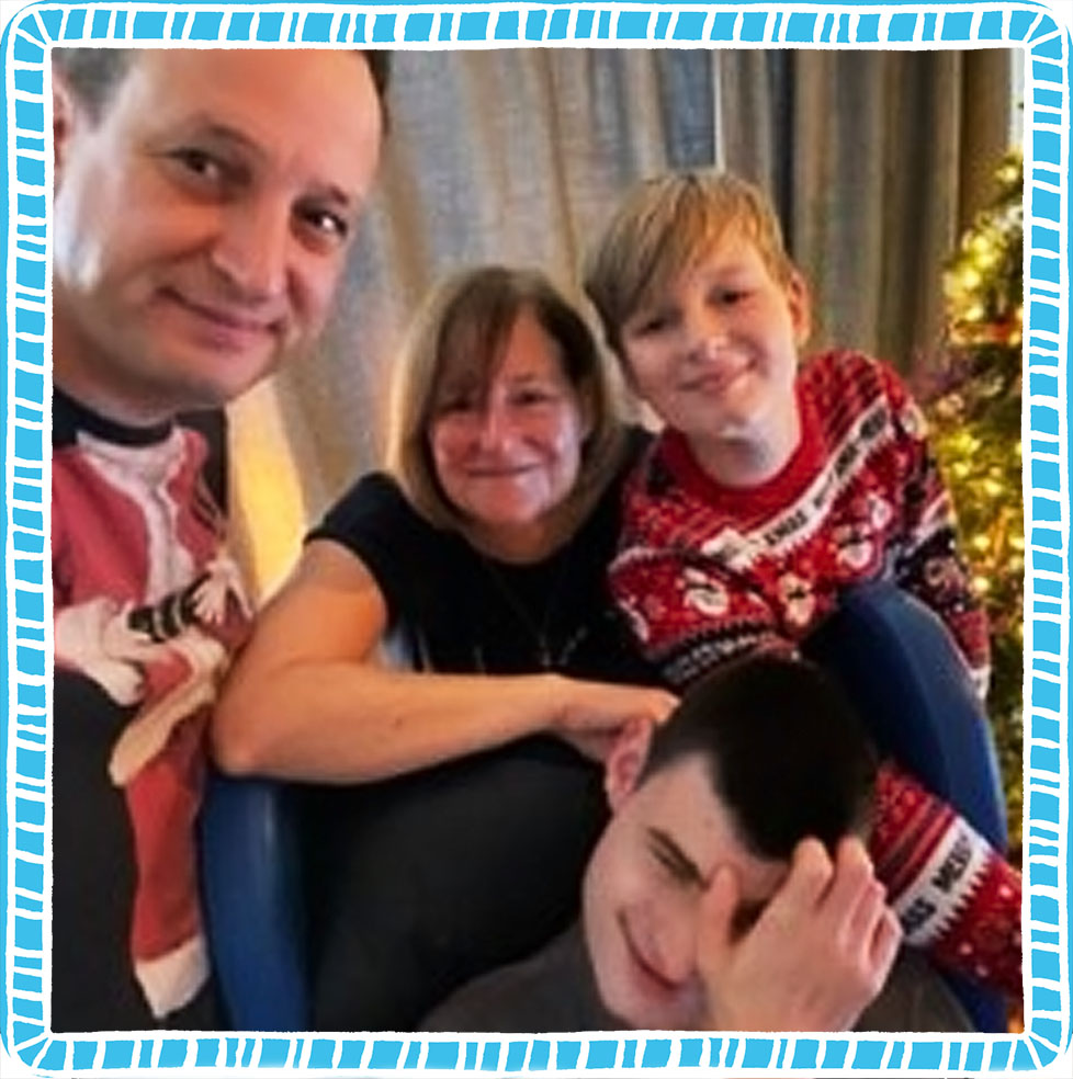 A picture of Thomas with his family at Christmas time, surrounded by a blue and white frame. 