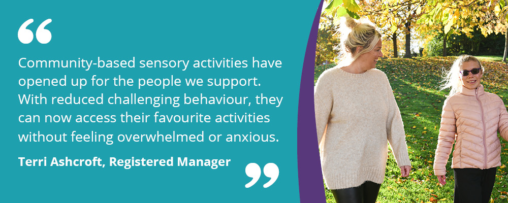 A picture of a person we support walking in the park with their support worker. Accompanying text reads, "Community-based sensory activities have opened up for the people we support. With reduced challenging behaviour, they can now access their favourite activities without feeling overwhelmed or anxious. Terri Ashcroft, Registered Manager." 