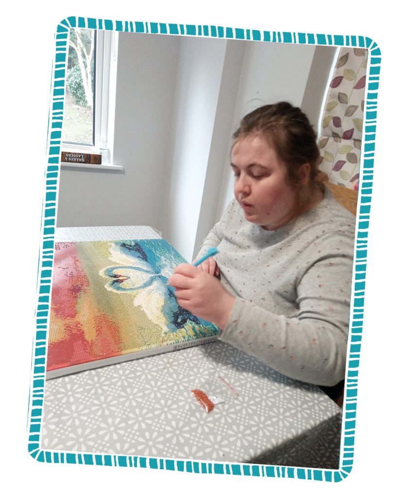 In image, Charlotte is creating her diamond art.